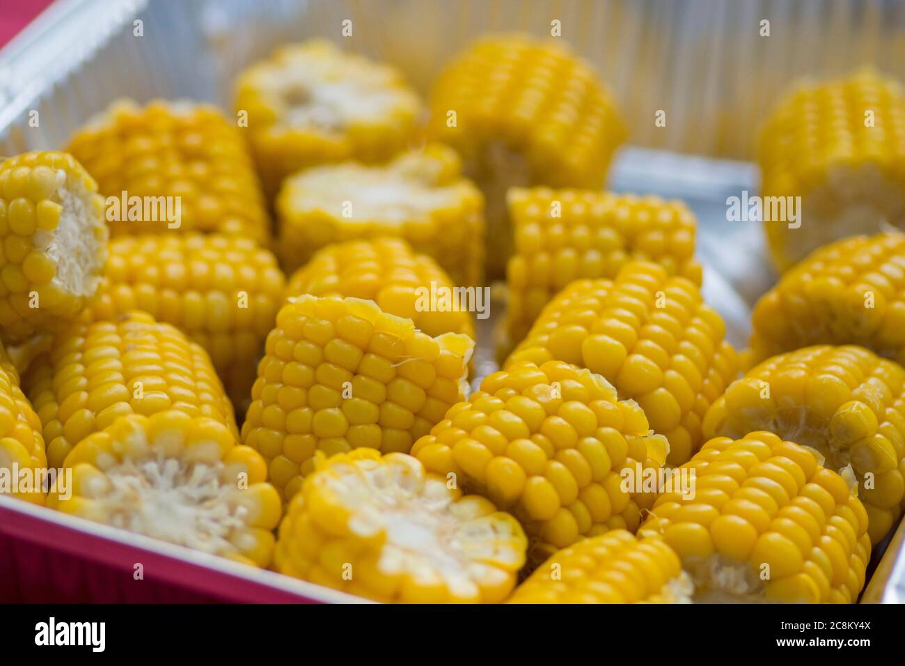 Shiny yellow sweet corn cobs in a metal plate Stock Photo