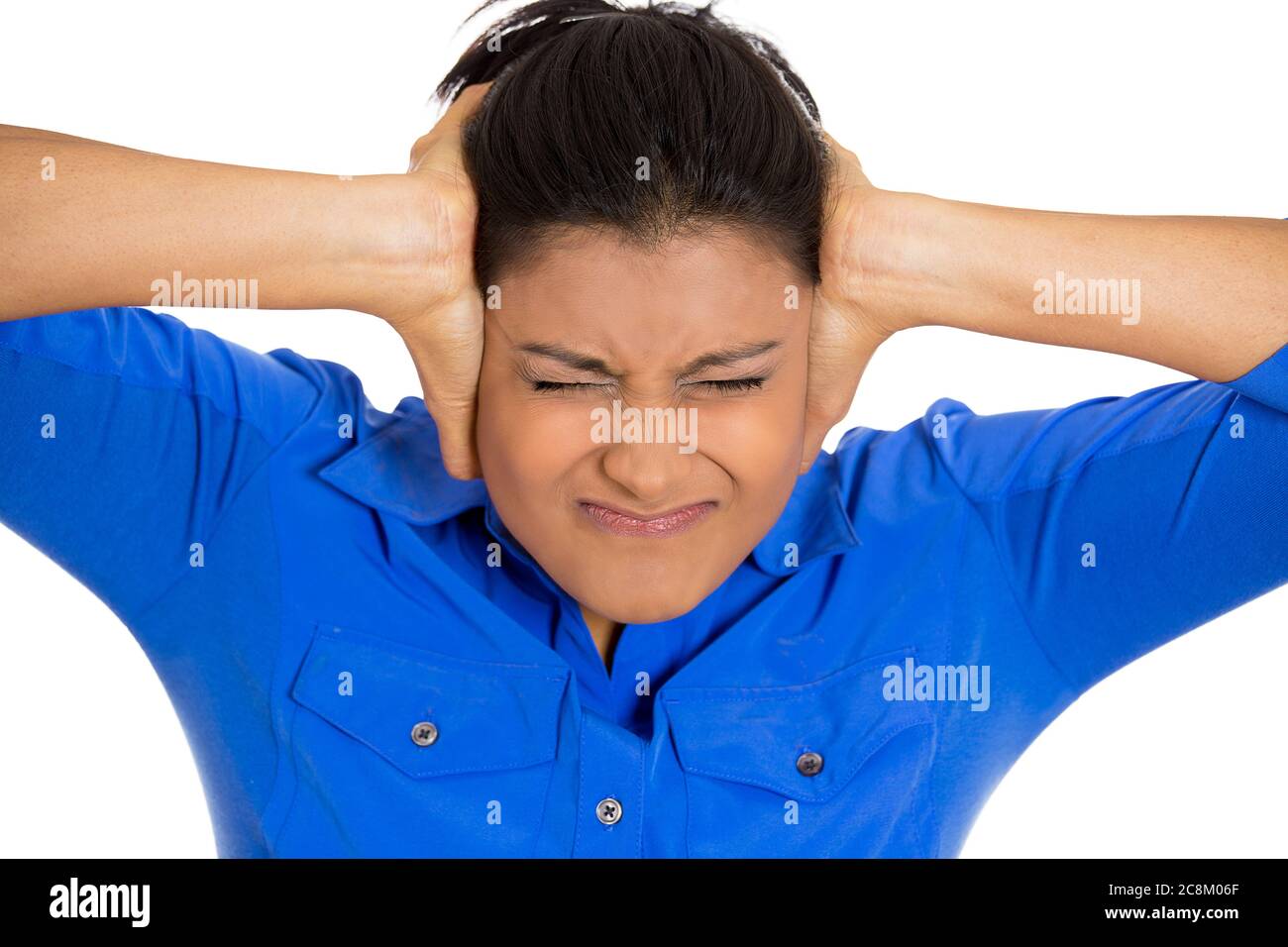 Closeup portrait of young stressed woman having headache pain, feeling overwhelmed, isolated on white background. Stock Photo