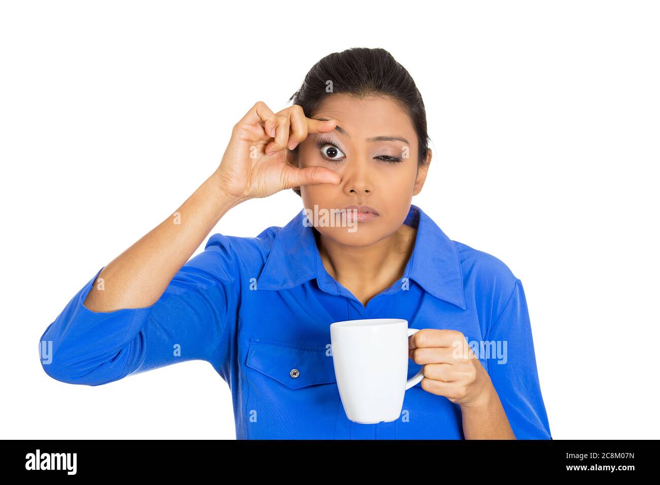 Portrait of a very tired sleepy young woman holding cup of coffee struggling not to crash stay awake, keeping eyes opened Stock Photo