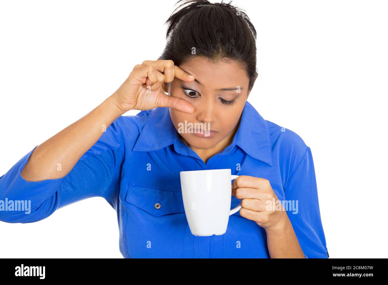 Portrait of a very tired sleepy young woman holding cup of coffee struggling not to crash stay awake, keeping eyes opened Stock Photo