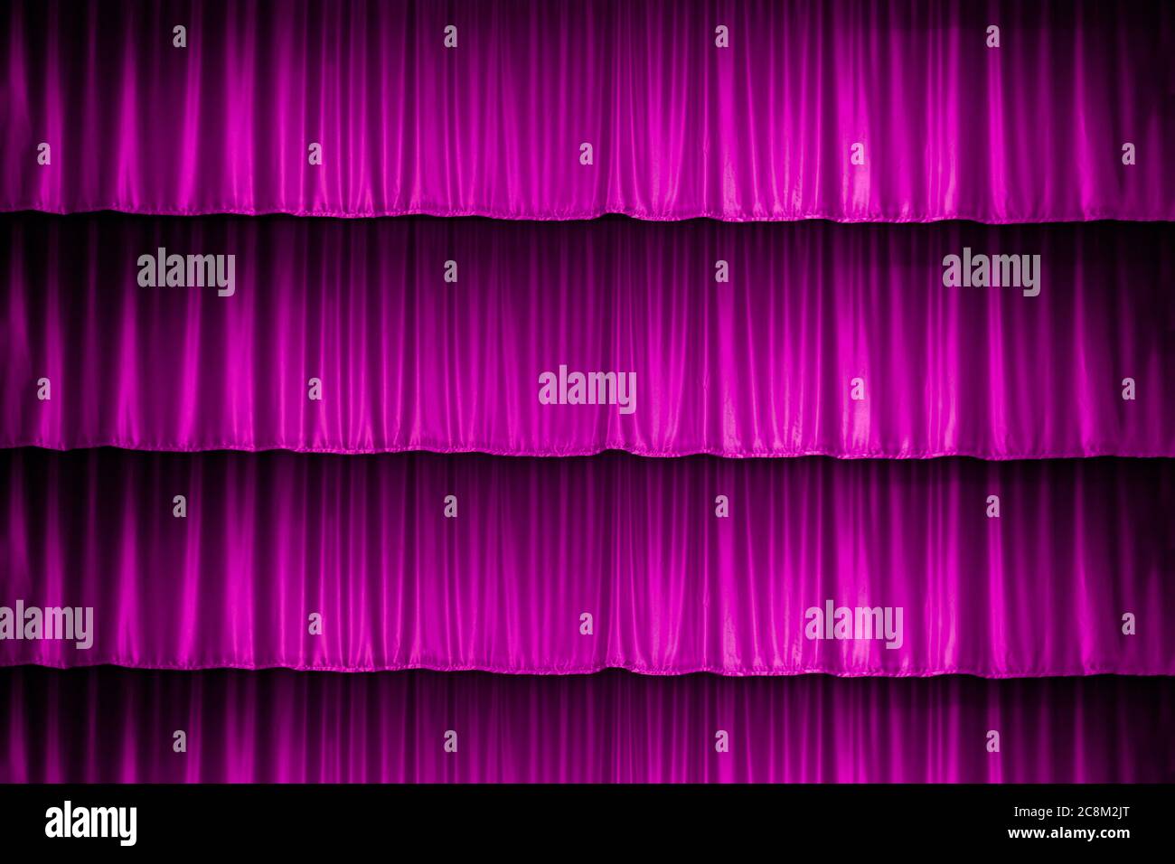 Theatrical dark red velvet curtain with golden fringe. Texture