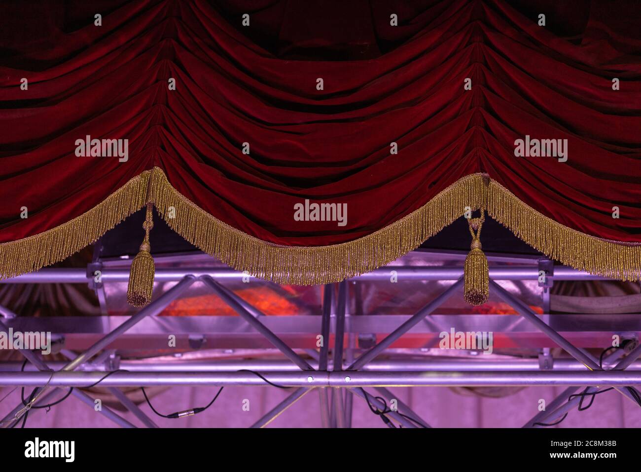 Theatrical dark red velvet curtain with golden fringe. Texture ...