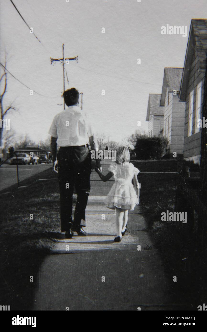Fine 70s vintage black and white lifestyle photography of a father and daughter spending time with each other on the sidewalk. Stock Photo