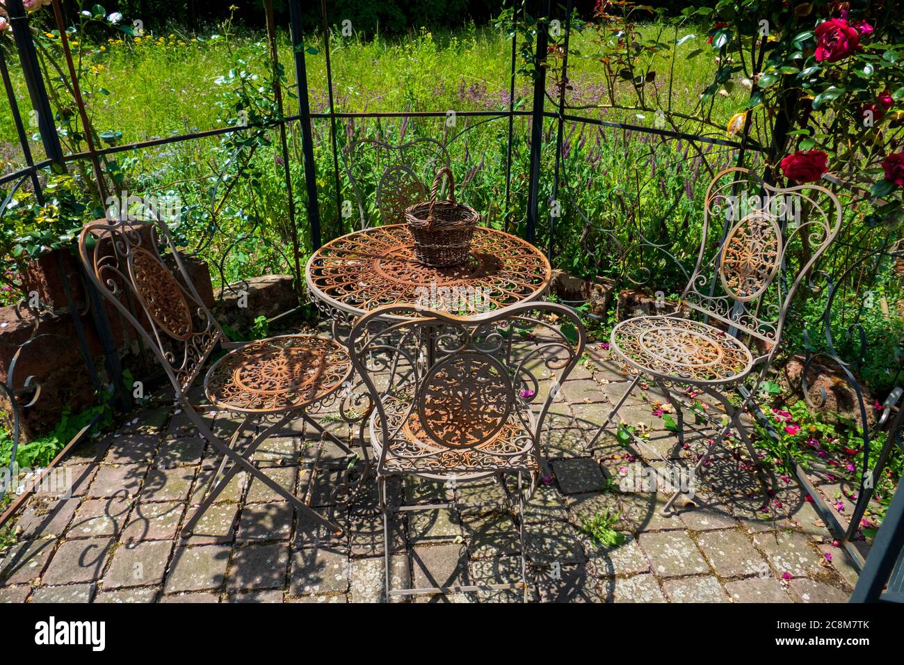 Alter rostiger, romantischer Stuhl und Tisch mit verspielten Ornamenten Stock Photo