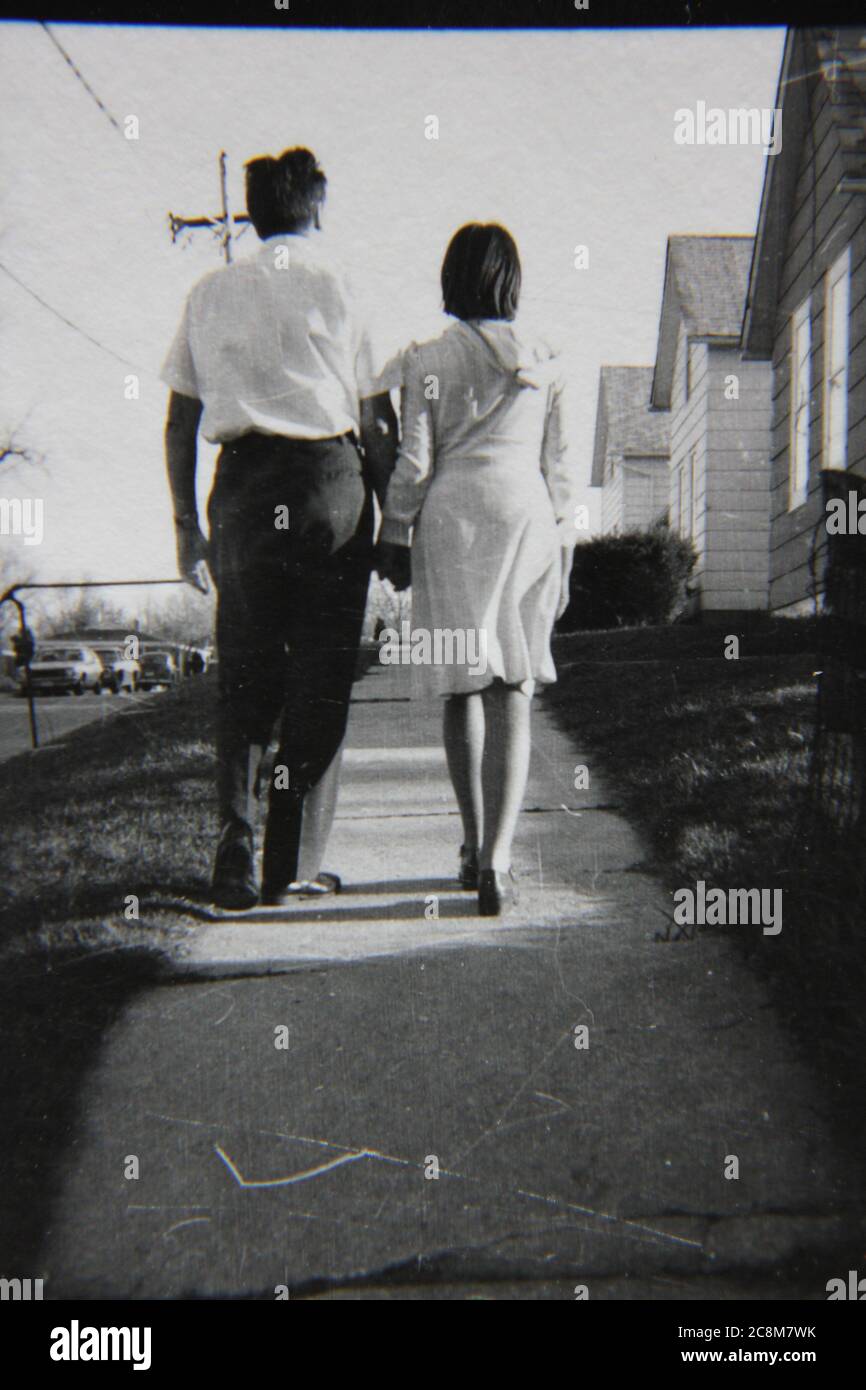 Fine 70s vintage black and white lifestyle photography of a father and daughter spending time with each other on the sidewalk. Stock Photo