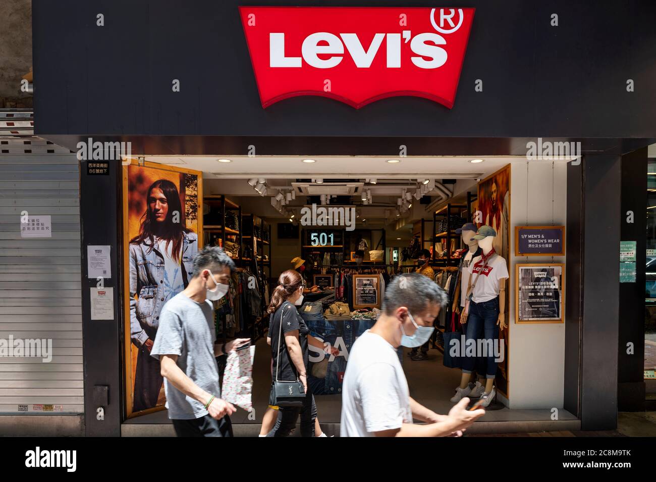 Pedestrians wearing face masks walk past an American clothing company brand  Levi´s store and logo seen in Hong Kong Stock Photo - Alamy