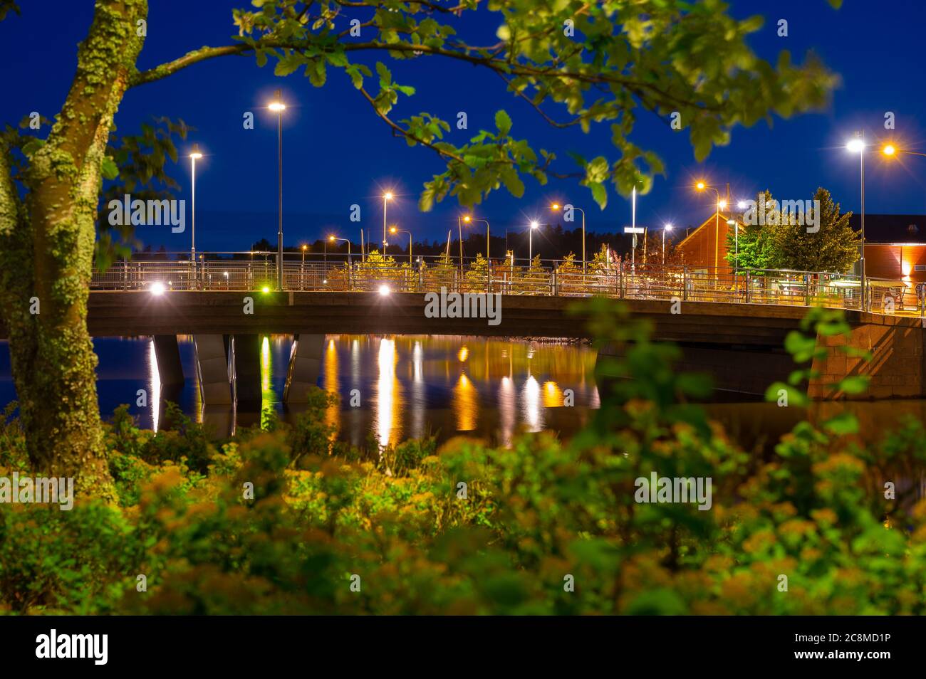 A long exposure shot of a calm bay area during night time. A bridge over a canal. Stock Photo