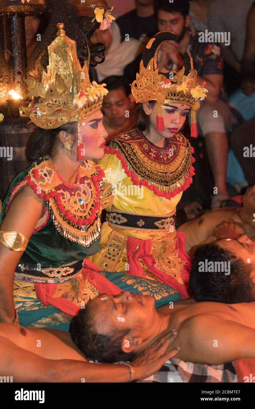 Dramatic photo of colorfully dressed Kecak dancers dressed in traditional, brightly colored costumes perform Balinese Hindu Ramayana Temple dance. Stock Photo