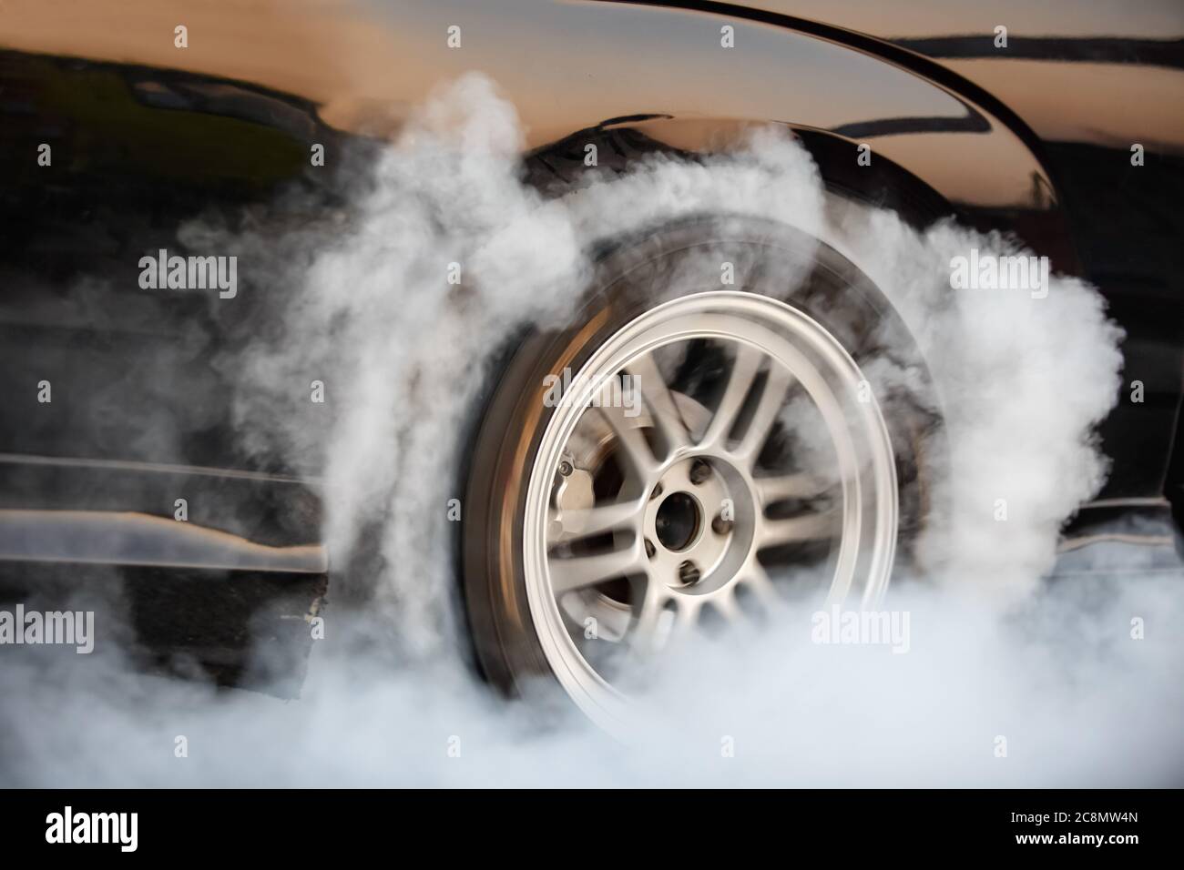 Drag racing car burns rubber off its tires in preparation for the race ...