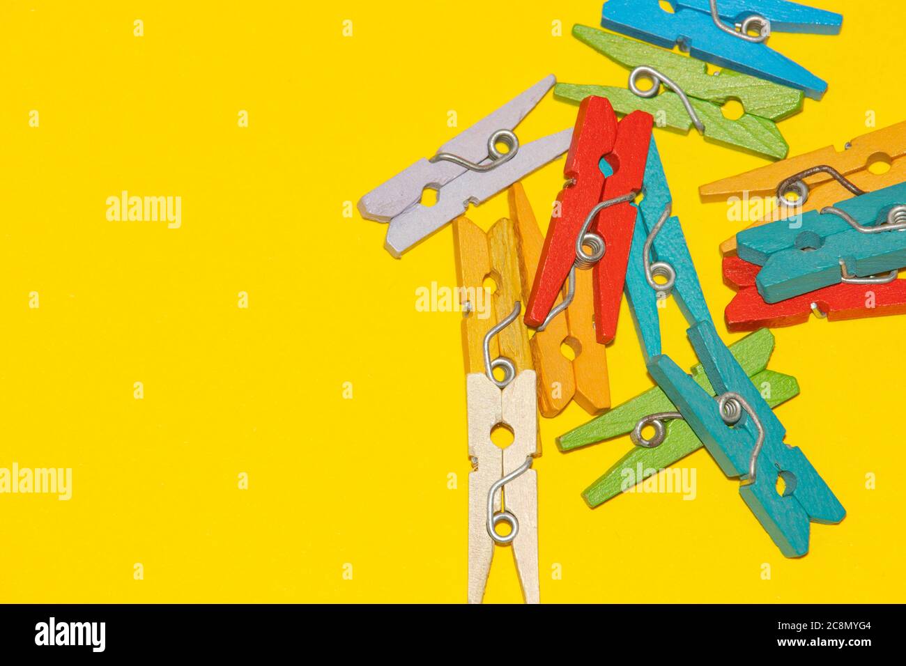 Colorful decorative wooden clothespins on yellow background Stock Photo