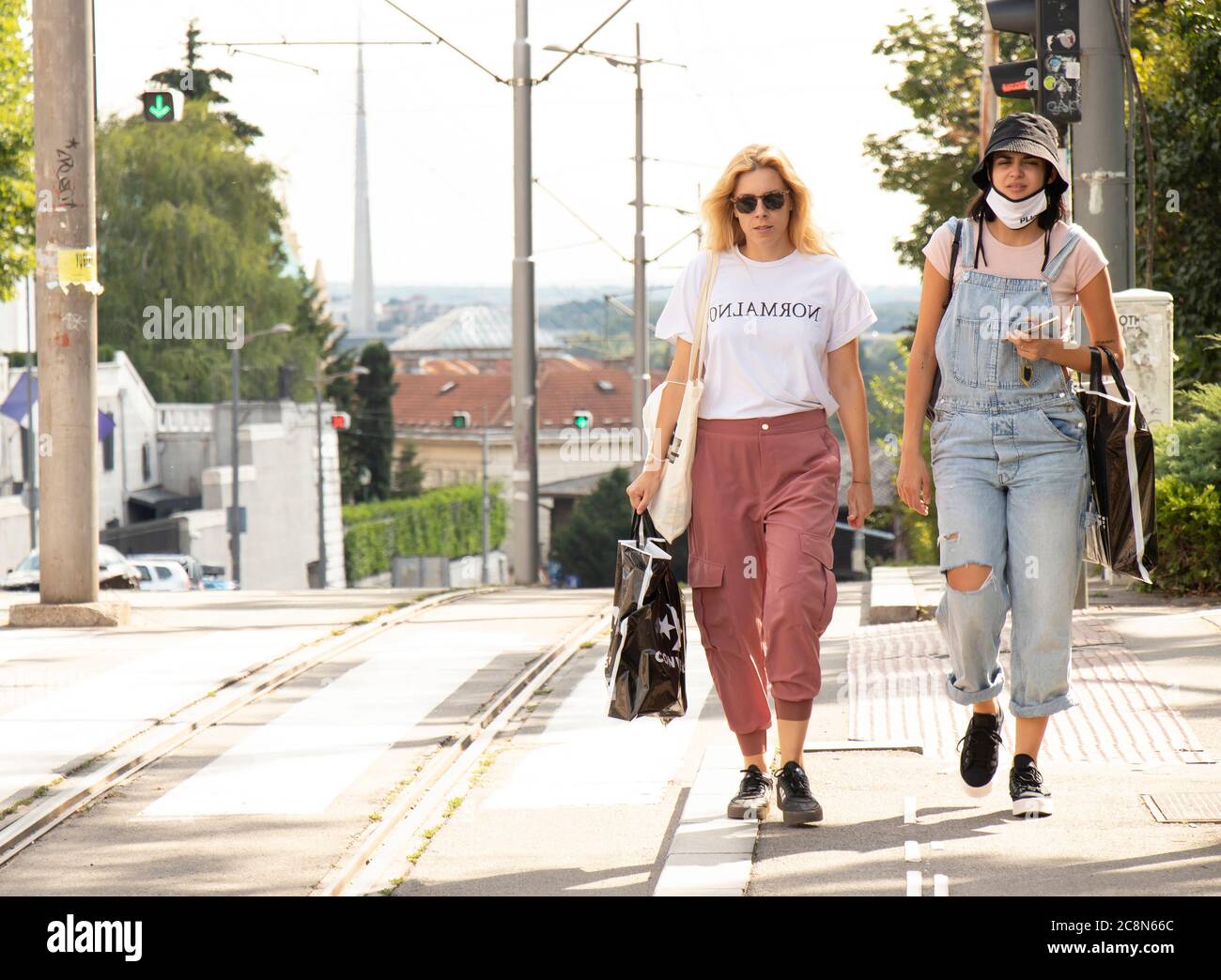 Belgrade, Serbia - July 16, 2020: Two young women casualy dressed in urban street style walking down the street Stock Photo