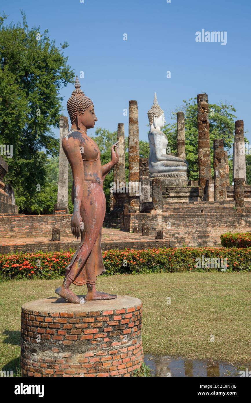 An old sculpture of a walking Buddha on the ruins of the Buddhist temple Wat Sa Si. Sukhothai, Thailand Stock Photo