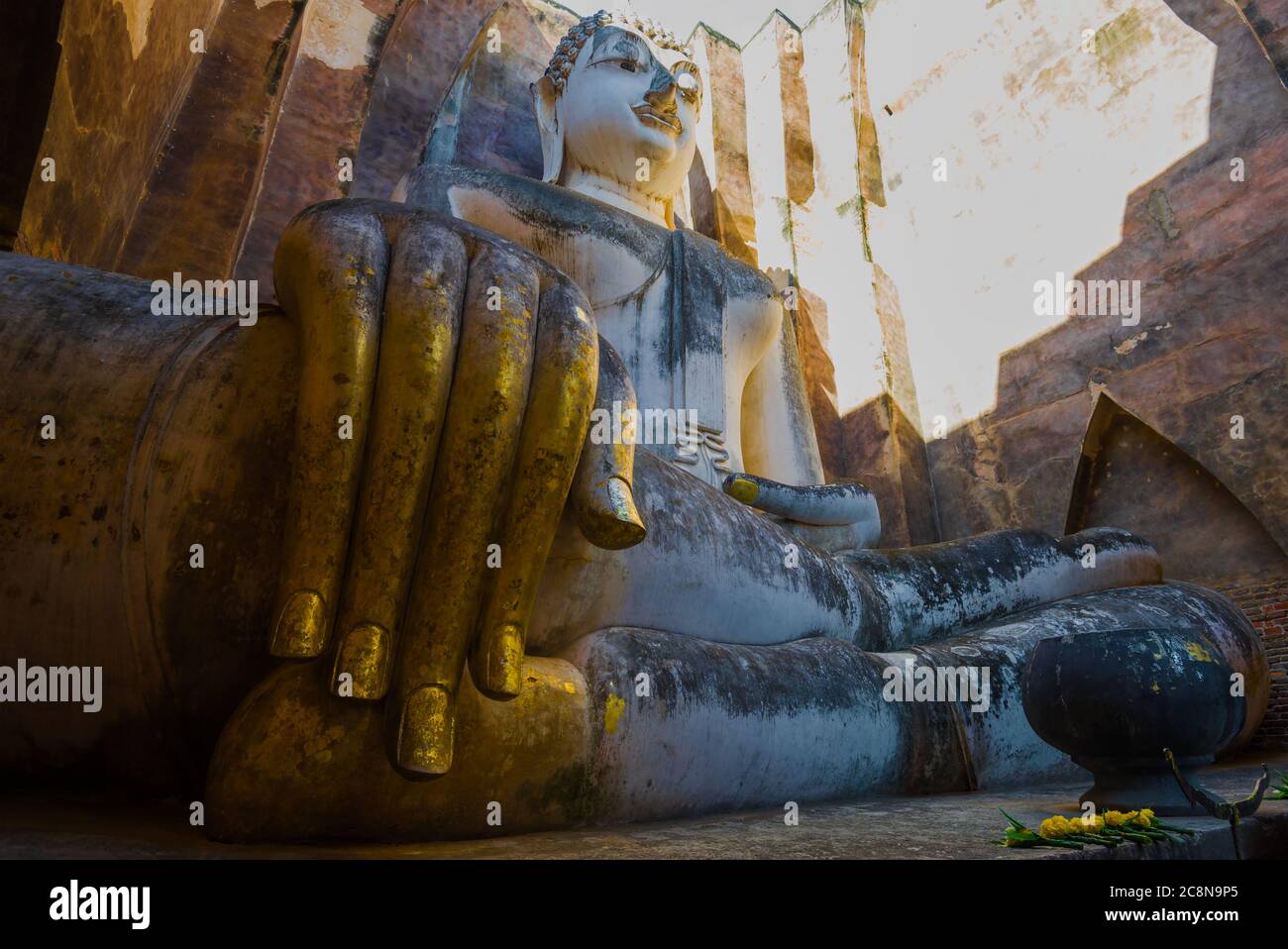 At the giant statue of a seated Buddha (Phra Achana). The ruins of the ancient Buddhist temple Wat Si Chum. Sukhothai, Thailand Stock Photo
