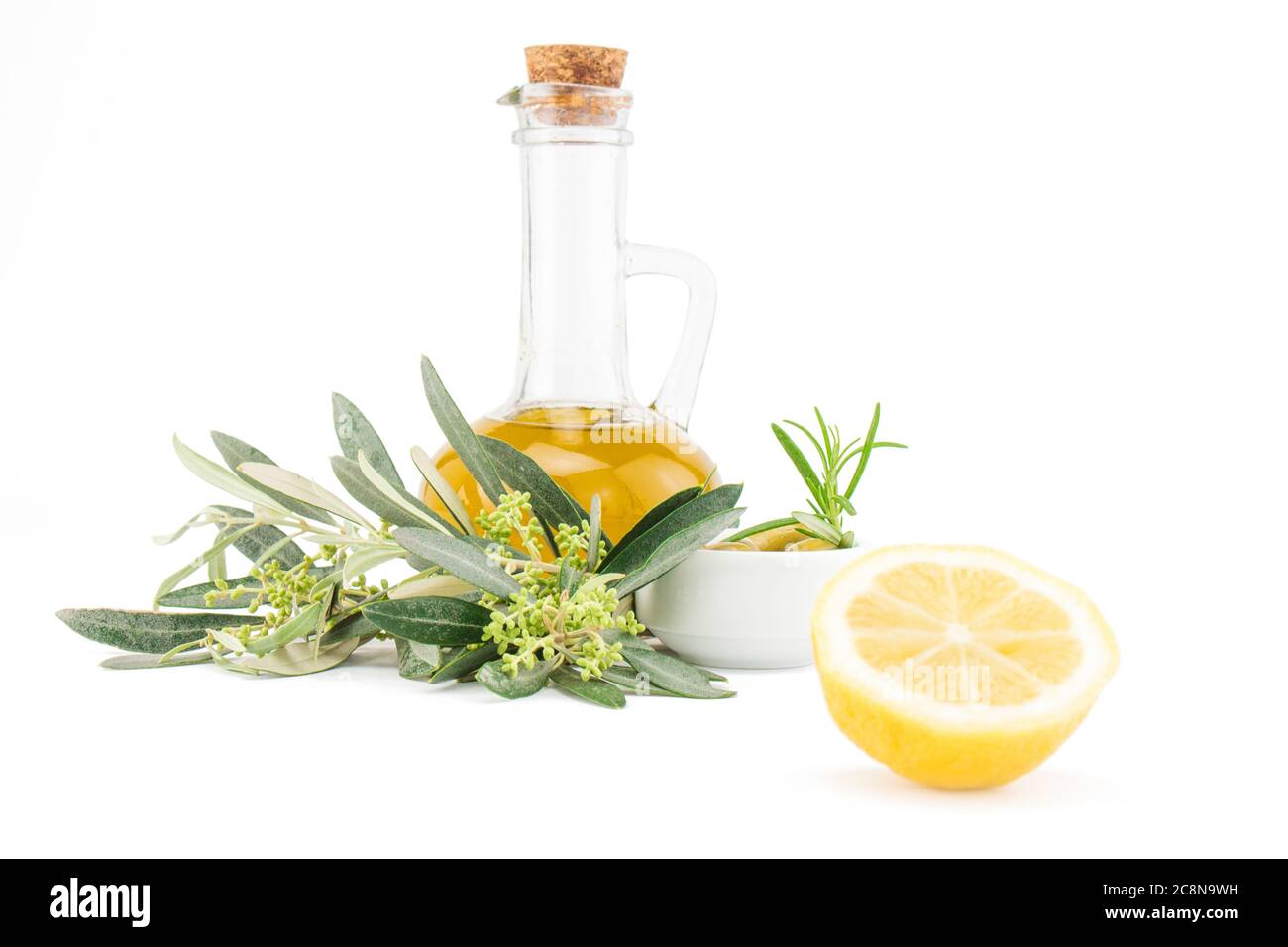 Glass bottle of premium virgin olive oil, lemon and some olives with ...