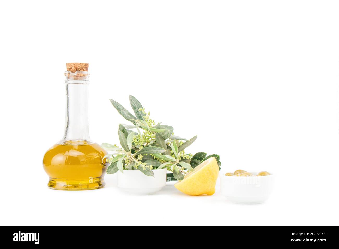 Glass bottle of premium virgin olive oil, lemon and some olives with ...