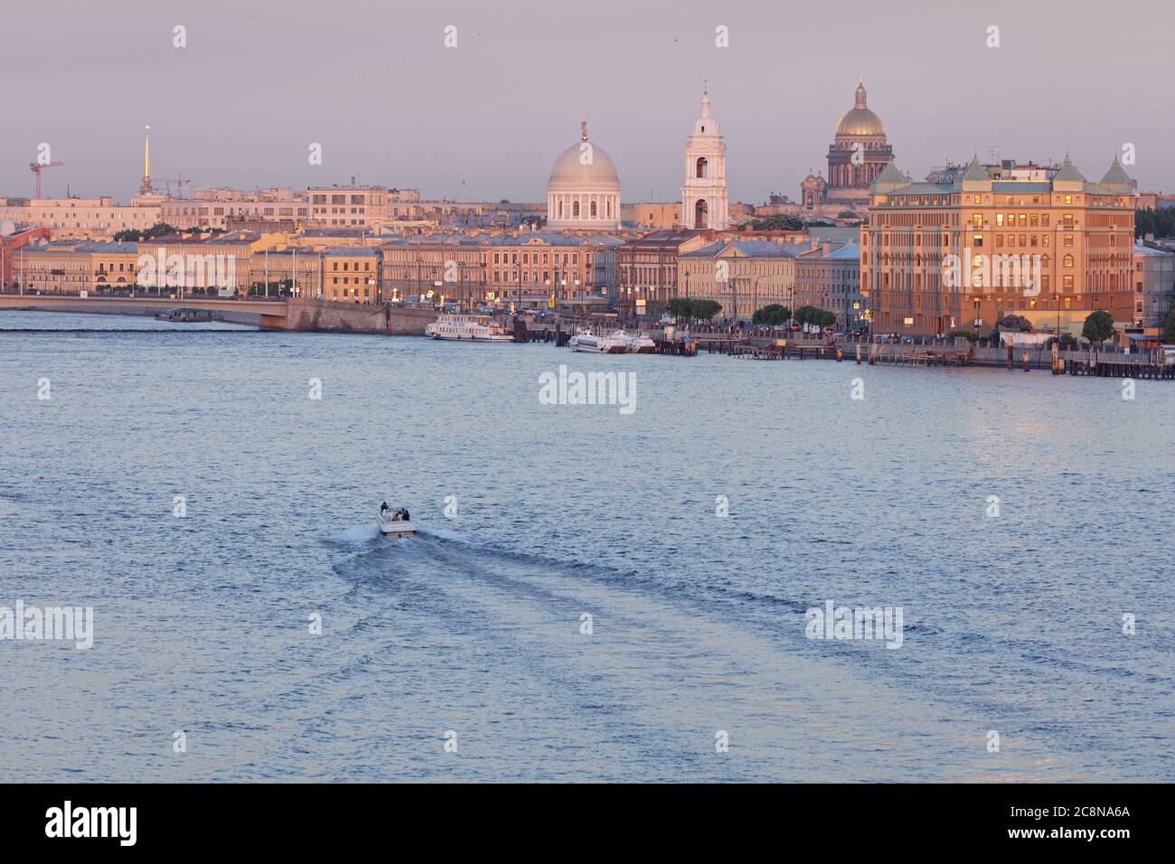 Cityscape of St. Petersburg, Russia with a boat on Little Neva against Vasilievsky island and a dominated golden dome of St. Isaac's cathedral Stock Photo