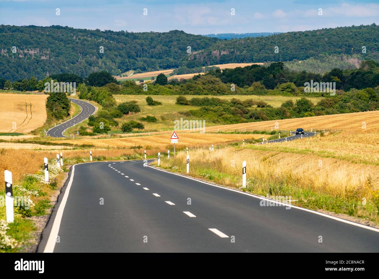 Curvy Country road, fields and forest, near Hofgeismar, in Hessen, Germany Stock Photo