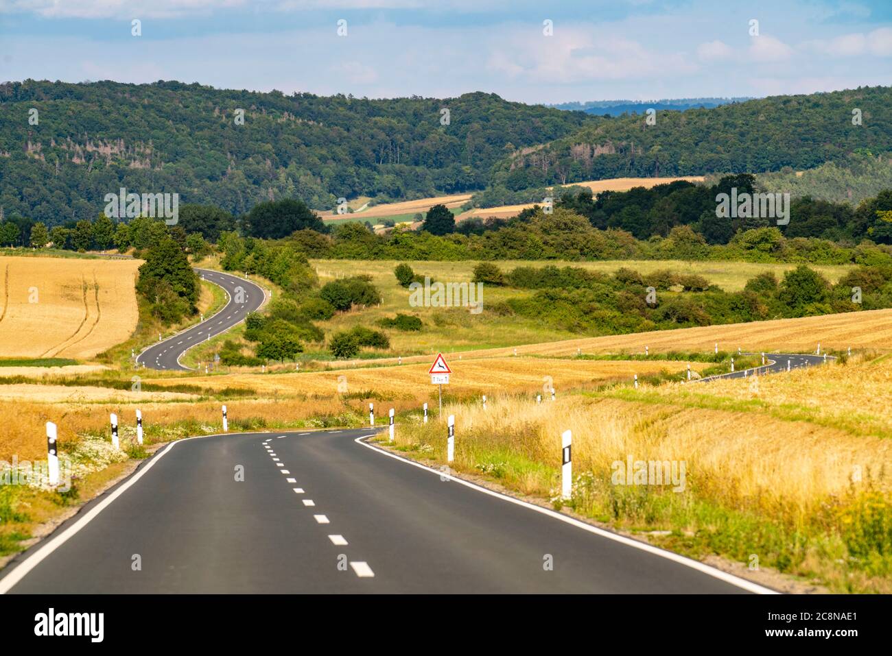 Curvy Country road, fields and forest, near Hofgeismar, in Hessen, Germany Stock Photo