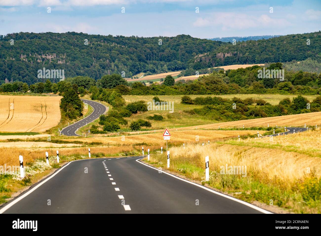 Curvy Country road, fields and forest, near Hofgeismar, in Hessen, Germany Stock Photo