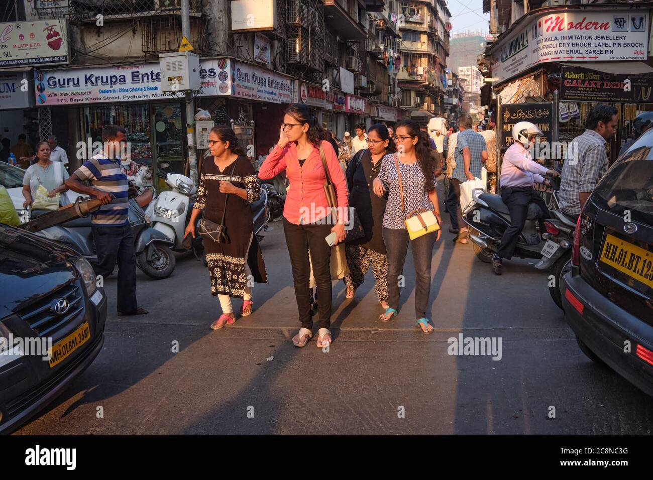 A group of women try to cross busy and congested Kalbadevi Road in Bhuleshwar trading area, Mumbai, India Stock Photo