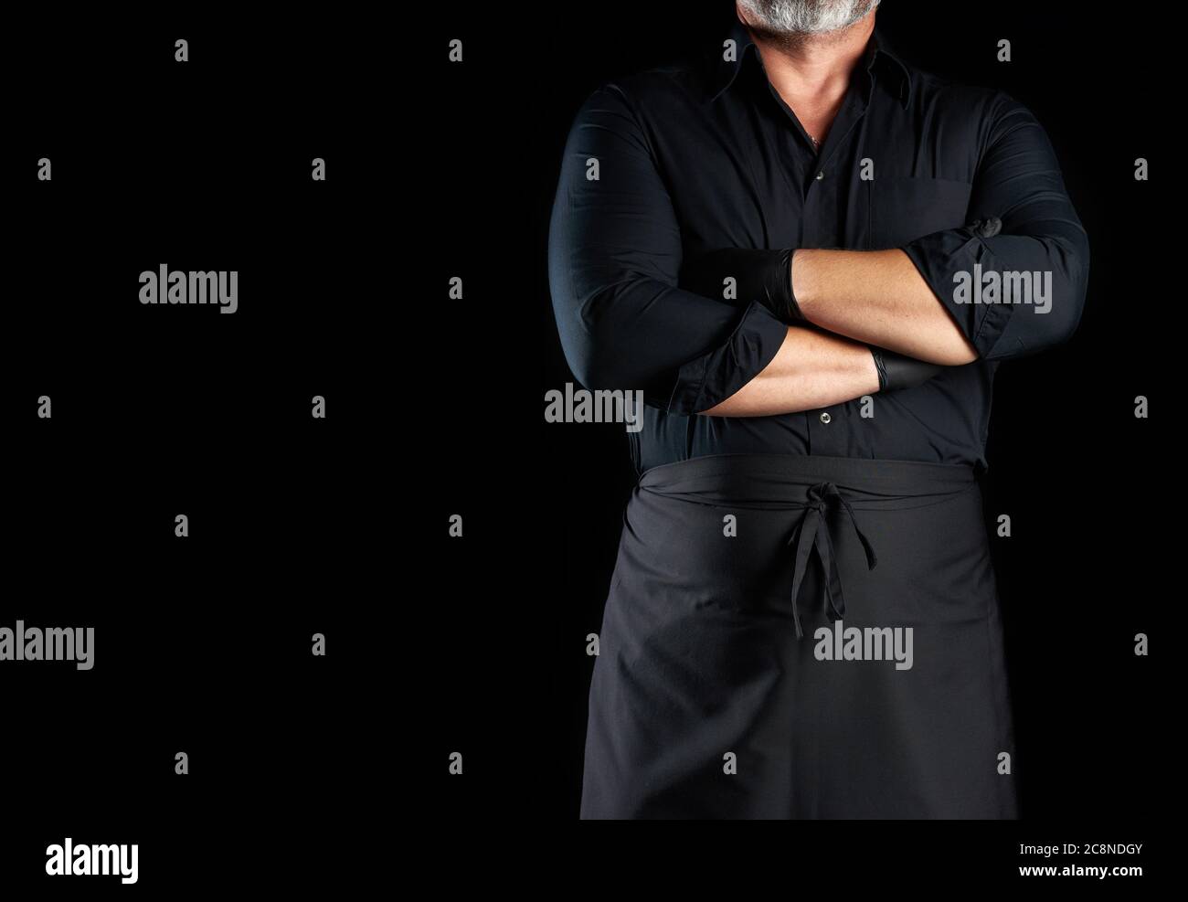 male chef in black uniform crossed his arms in front of his chest on a ...