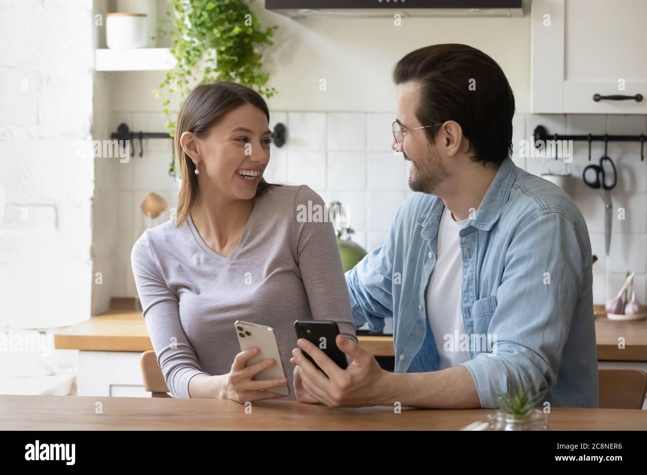 Smiling millennial couple have fun using cellphone gadgets Stock Photo