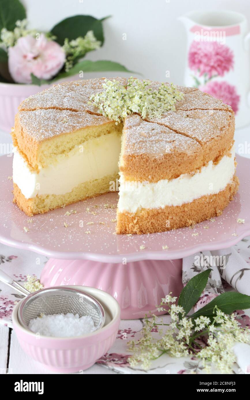 elder cream cake on cake plate decorated with elder flowers Stock Photo