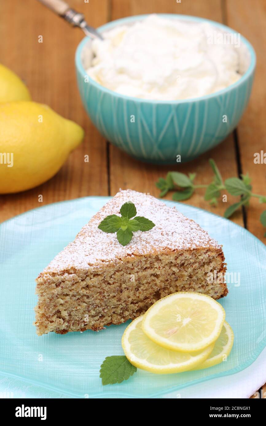 lemon cake on the plate and whipped cream in bowl Stock Photo