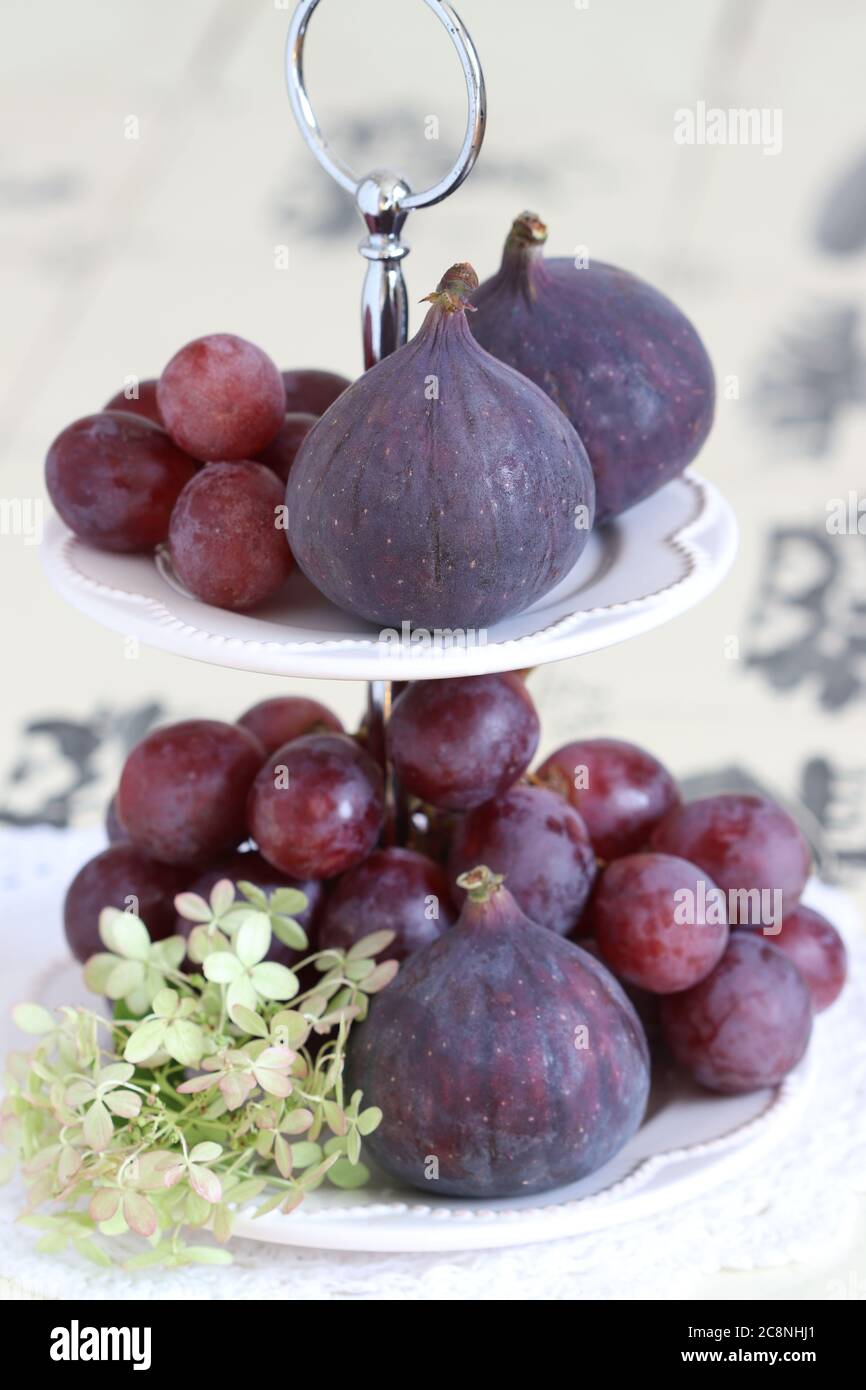 fresh figs and grapes on the tiered cake stand Stock Photo