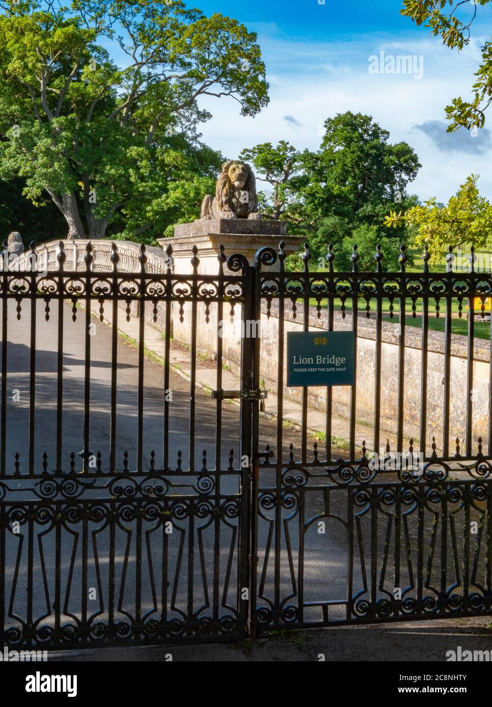 Lion Bridge and its iron gates. An 18th century, stone built crossing over the lake on the Burghley House estate. Stamford, Lincolnshire, England, UK. Stock Photo