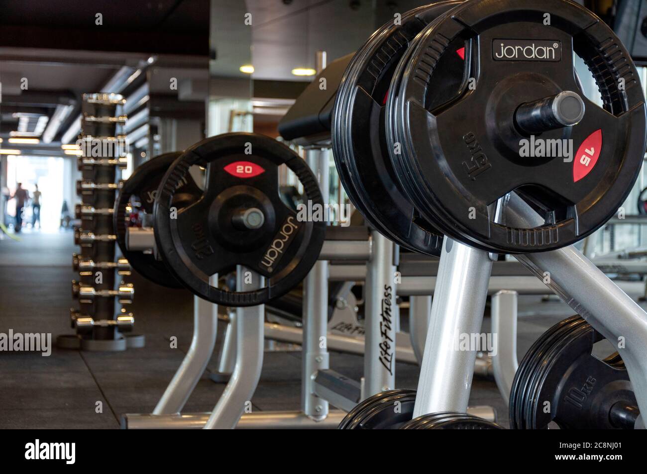 Jordan weight plates on Life Fitness shoulder press stands in empty gym  interior Stock Photo - Alamy