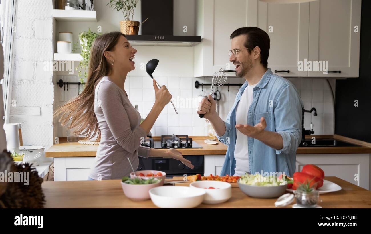 Funny young housewife cooking in kitchen Stock Photo - Alamy