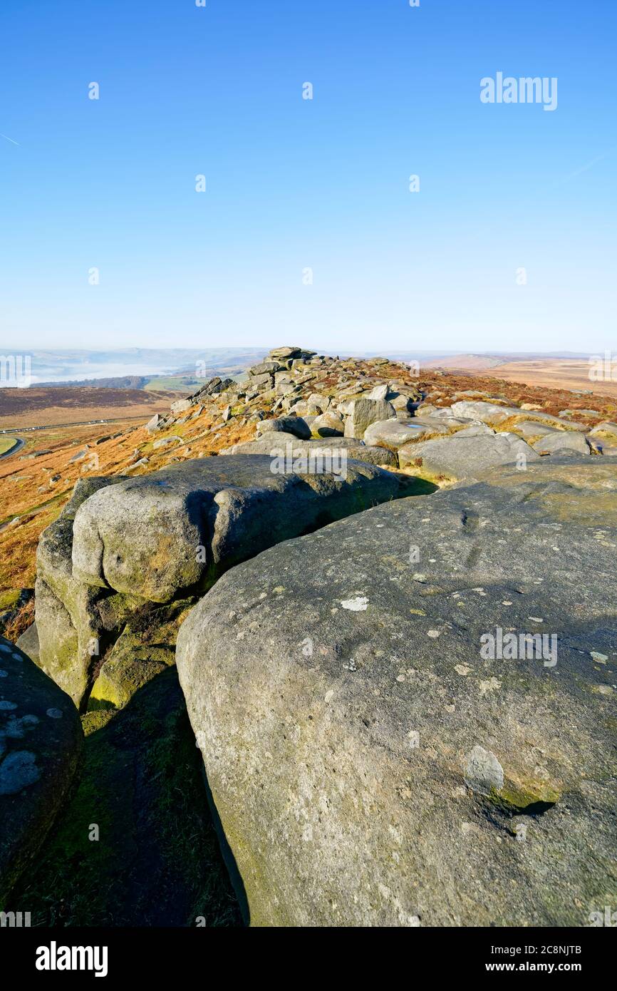 Along the boulder strewn ridge line of Stanage Edge on a misty winter morning Stock Photo