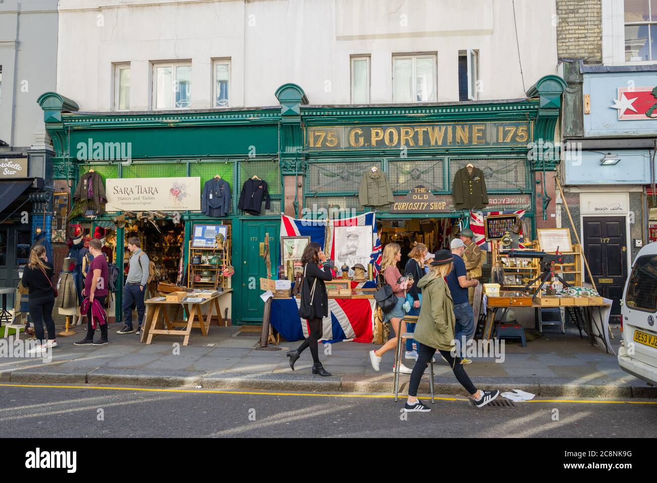 Visitors to Portobello Road, Notting Hill, London, strolling and browsing. British flag and Lord Kitchener poster in the middle of the picture. Stock Photo