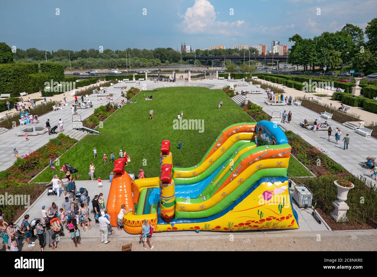 WARSAW, POLAND - JUNE 2, 2019: People with little children, kids playing and having fun at huge inflatable slide in gardens of the Royal Castle Stock Photo