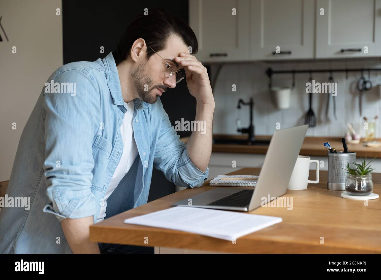 Pensive man work look at laptop screen thinking Stock Photo - Alamy