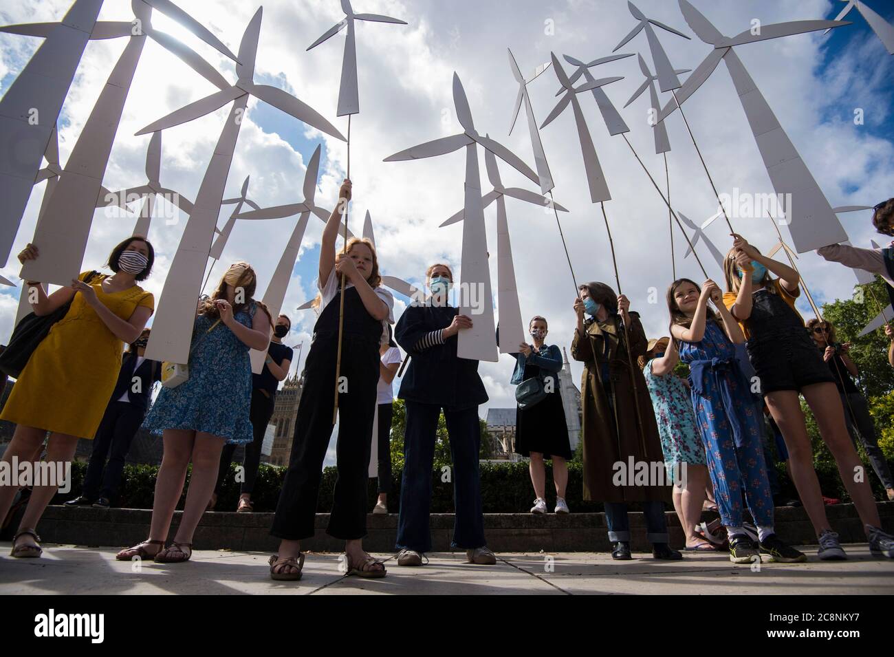 Parents and children create a 'wind farm' in Parliament Square, before marching to Downing Street in London as they call for a green economic recovery from Covid-19. Stock Photo