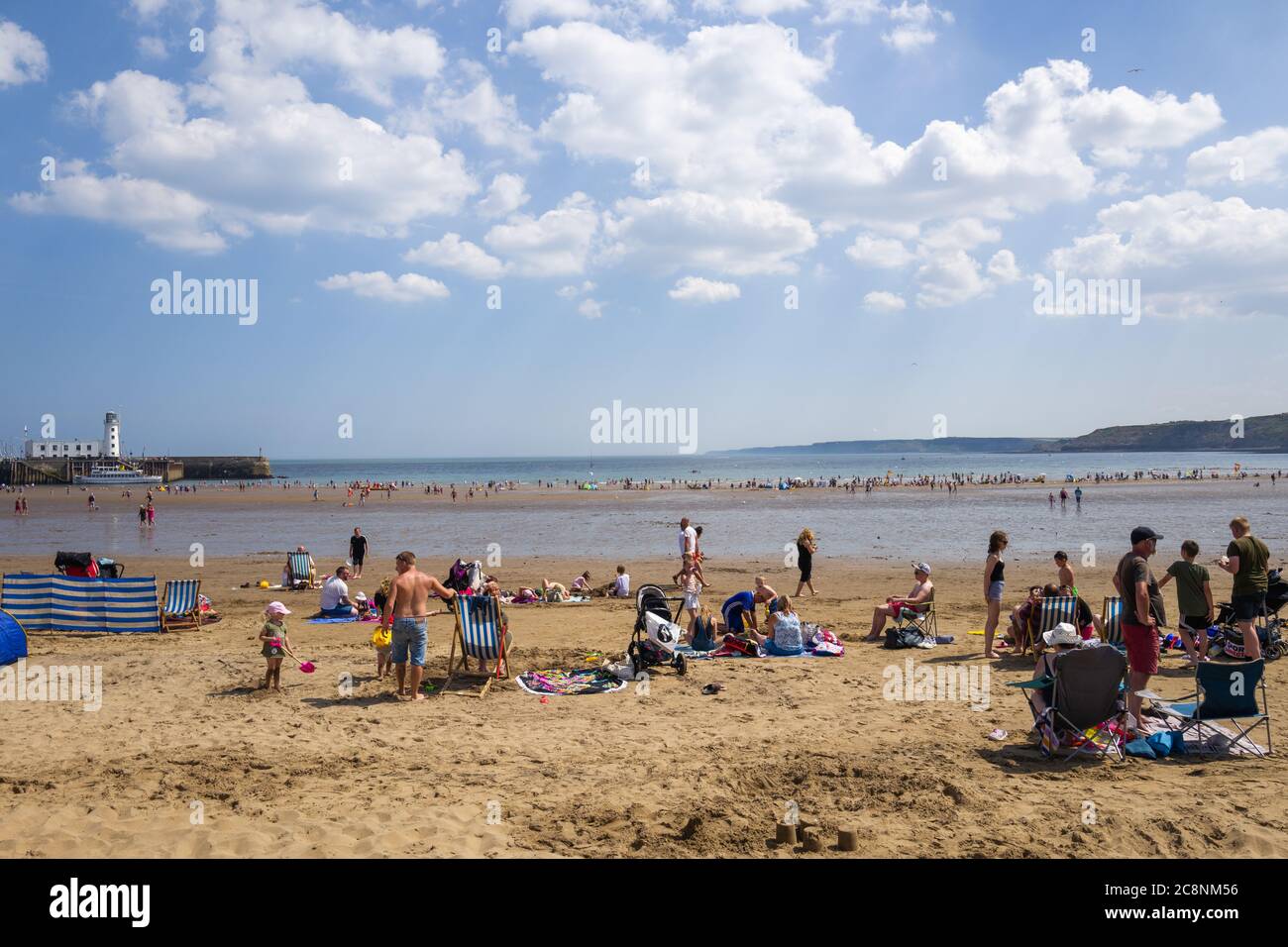 Visitors on a beautiful summer's day at Scarborough beach, North Yorkshire, UK. Ideal for staycation. Stock Photo