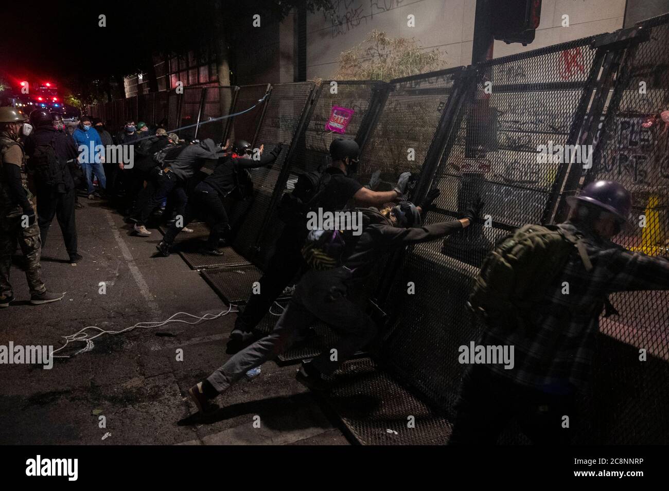 Portland, Oregon, USA. 26th July, 2020. Demonstrators attempt to push down a metal barricade at the Mark O. Hatfield United States Courthouse in Portland, Ore. on Sunday, July 26, 2020. Credit: Daniel Kim/ZUMA Wire/Alamy Live News Stock Photo