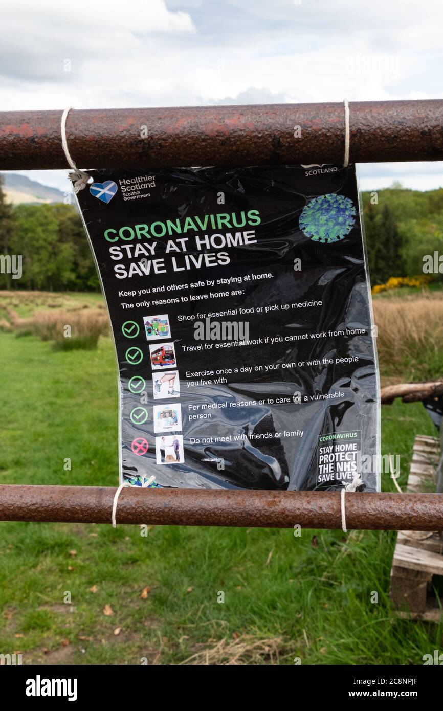 Coronavirus Stay at Home Save Lives sign fastened onto farm gate next to Finnich Glen or Devils Pulpit Scotland to try and deter visitors, Scotland, Stock Photo