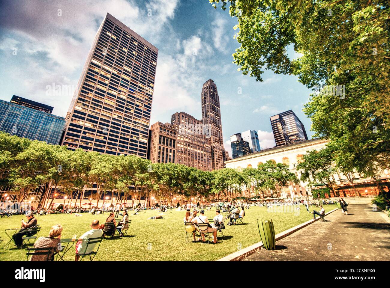 NEW YORK - MAY 19: People relax in Bryant Park on a mild spring evening, May 19, 2013 in New York. Bryant Park is a popular 9.6 acre park located adja Stock Photo