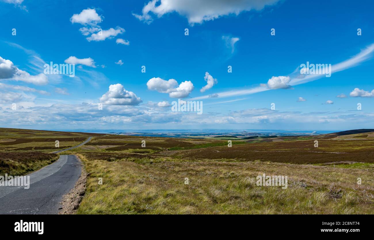 View over moorland on quiet country road with Firth of Forth in distance, Lammermuir Hills, East Lothian, Scotland, UK Stock Photo
