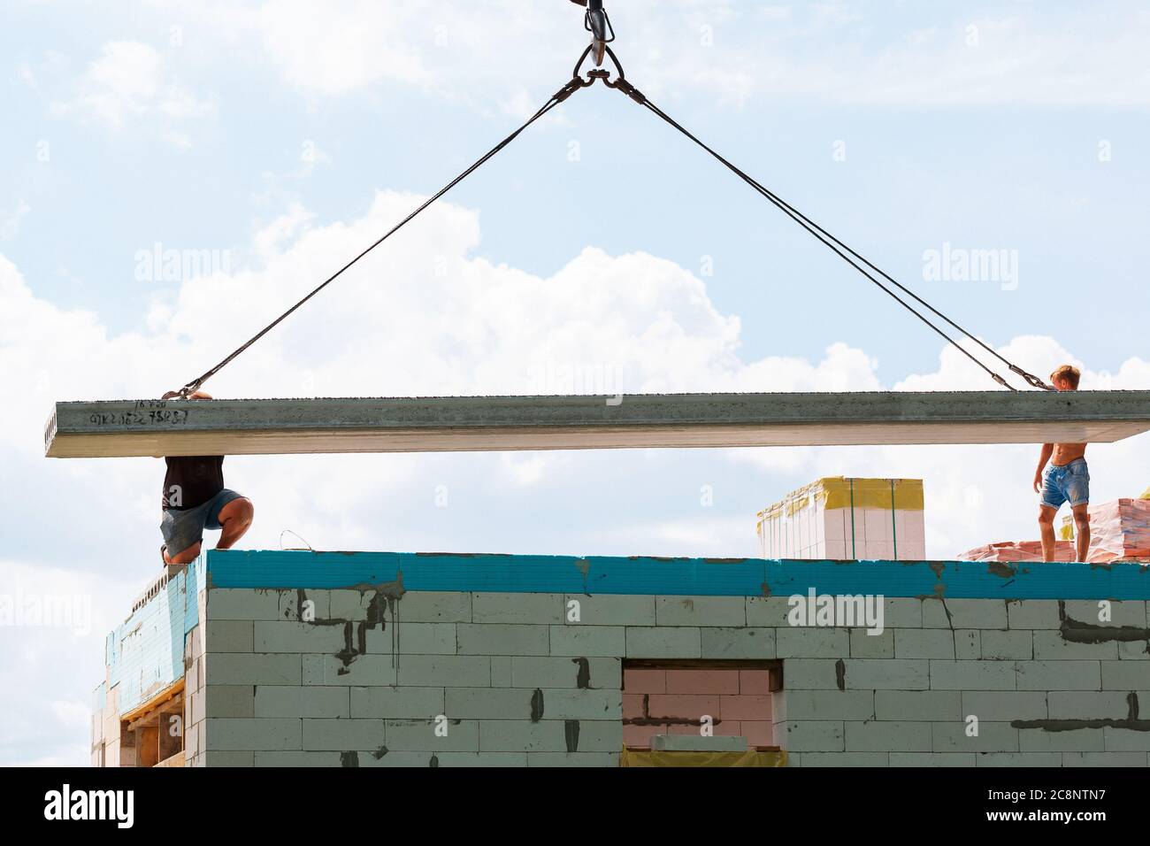 Builder worker installing concrete floor slab panel at building