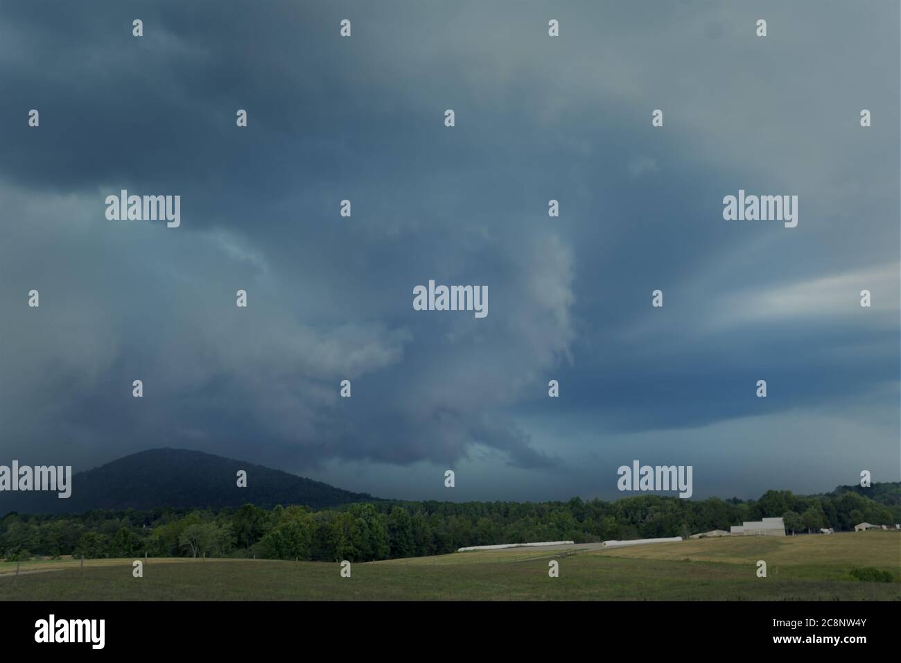 An intense summer thunderstorm looms over a mountain and a Virginia farm, threatening the surrounding countryside. Stock Photo