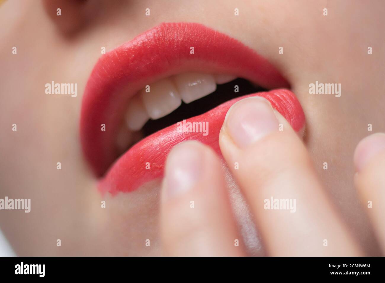 Putting on red lipstick Stock Photo