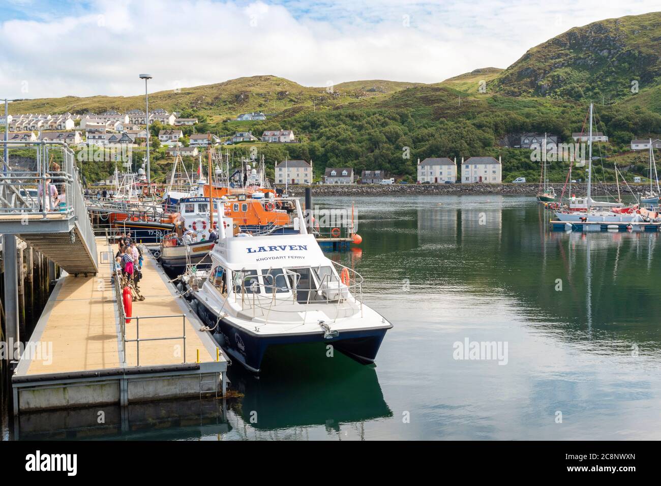 MALLAIG HARBOUR LOCHABER WEST COAST SCOTLAND WITH BOATS INCLUDING A LIFEBOAT AND PASSENGERS FOR THE LARVEN KNOYDART FERRY AND WESTERN ISLES Stock Photo