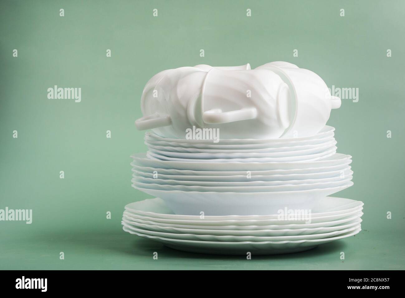 table set of white porcelain dishes on a green background Stock Photo