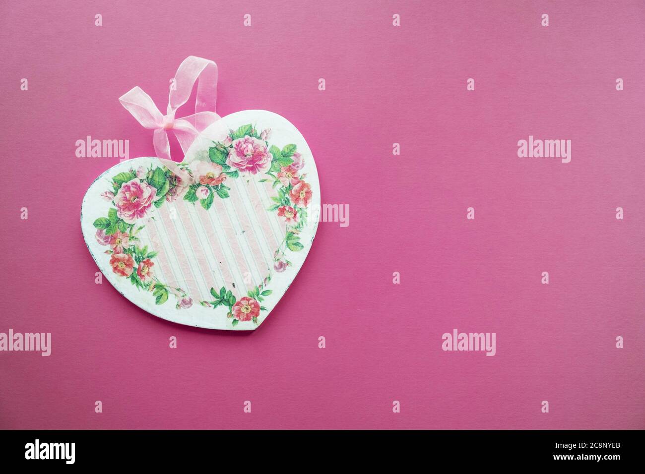 Valentine's card background - wooden heart decorated in decoupage technique Provencal style on a pink background with place for text. A nice gift for Stock Photo