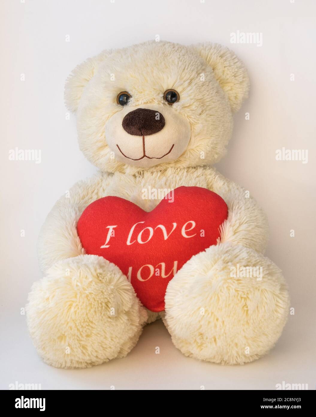 Cute Teddy Beige Bear Sitting On A White Background He Holds A Big Red Heart With The Text I Love You Stock Photo Alamy
