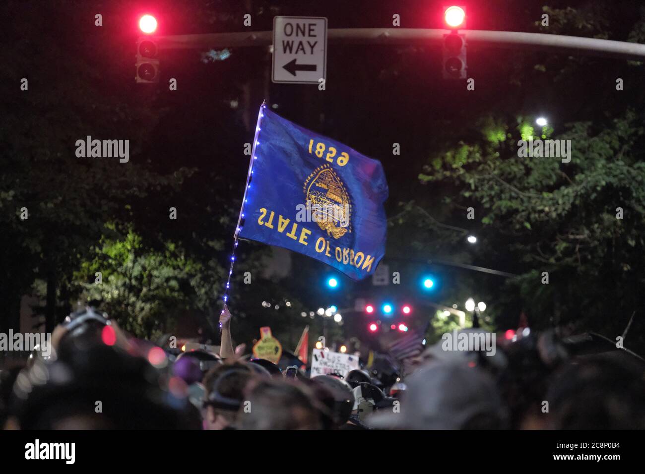 Portland, USA. 26th July, 2020. An upside-down Oregon flag is held in the air as protesters fill the streets demanding that federal officers leave the federal courthouse in Portland, Ore., on July 26, 2020. (Photo by Alex Milan Tracy/Sipa USA) Credit: Sipa USA/Alamy Live News Stock Photo